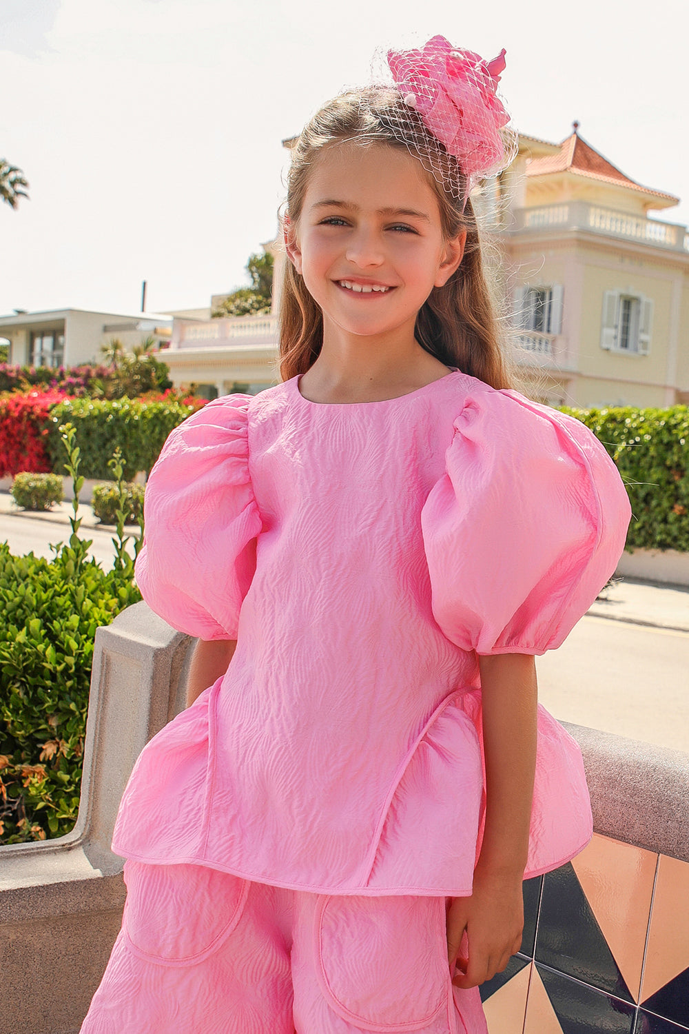 Bright pink jacquard top with voluminous sleeves and tie-up back straps