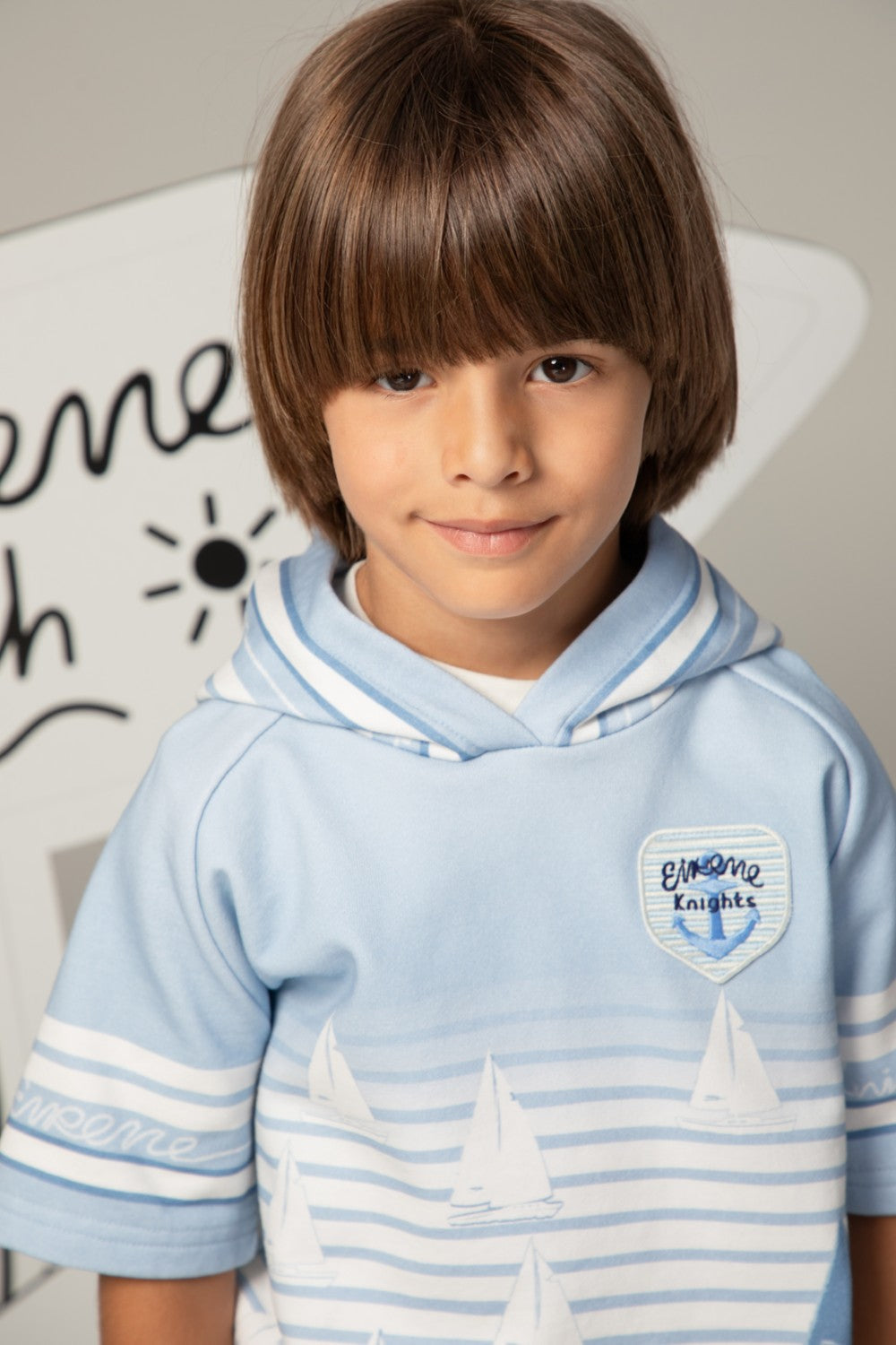 Light blue short-sleeved striped hoodie with sailboat print and Eirene Knights patch