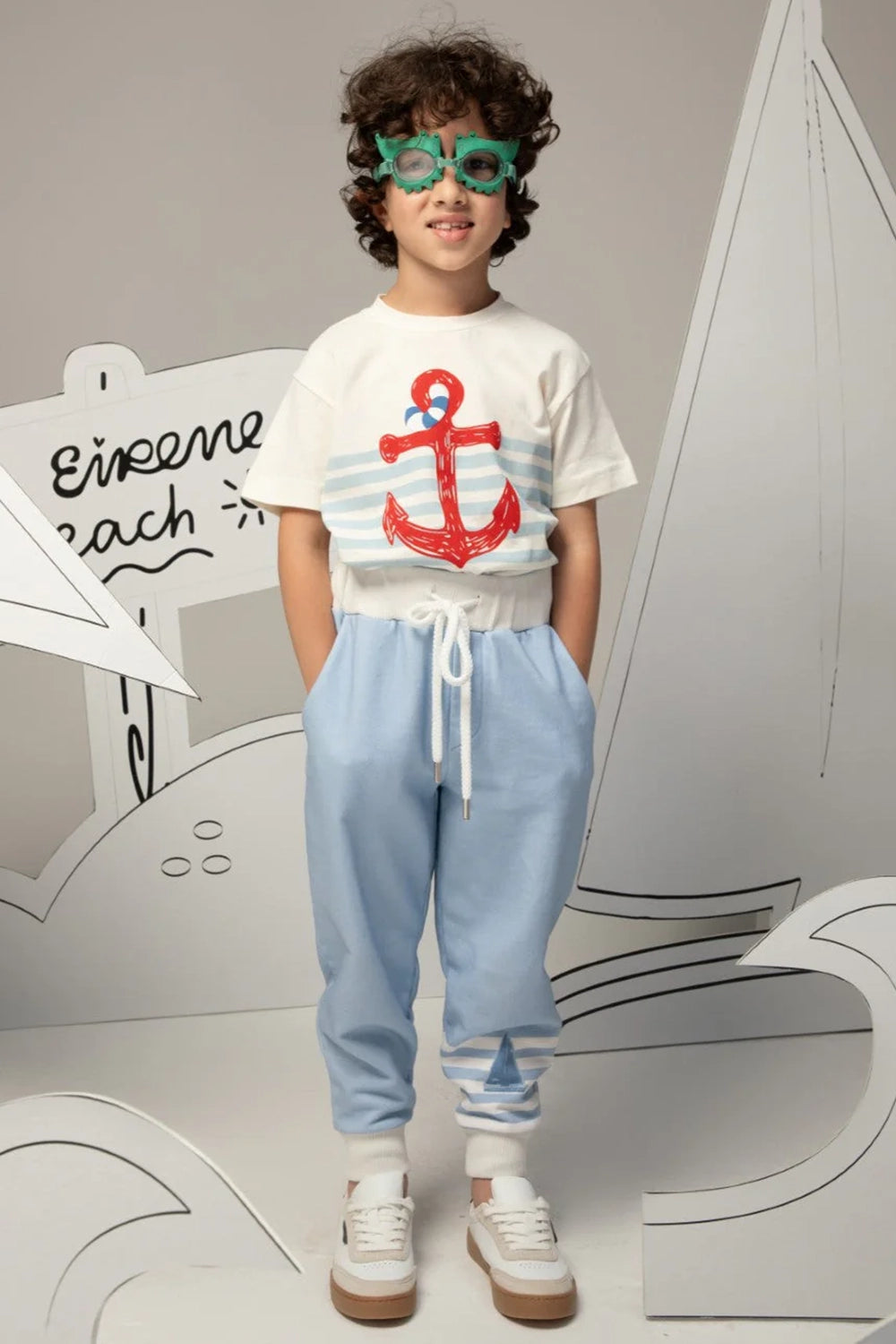 Light blue pants with white striped cuffs and a small sailboat print motif on the leg