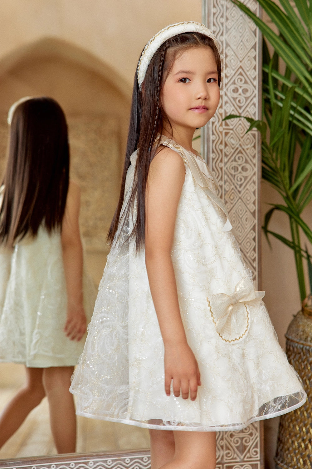 Ivory A-line lace dress with gold shoulder bows and pocket bow details