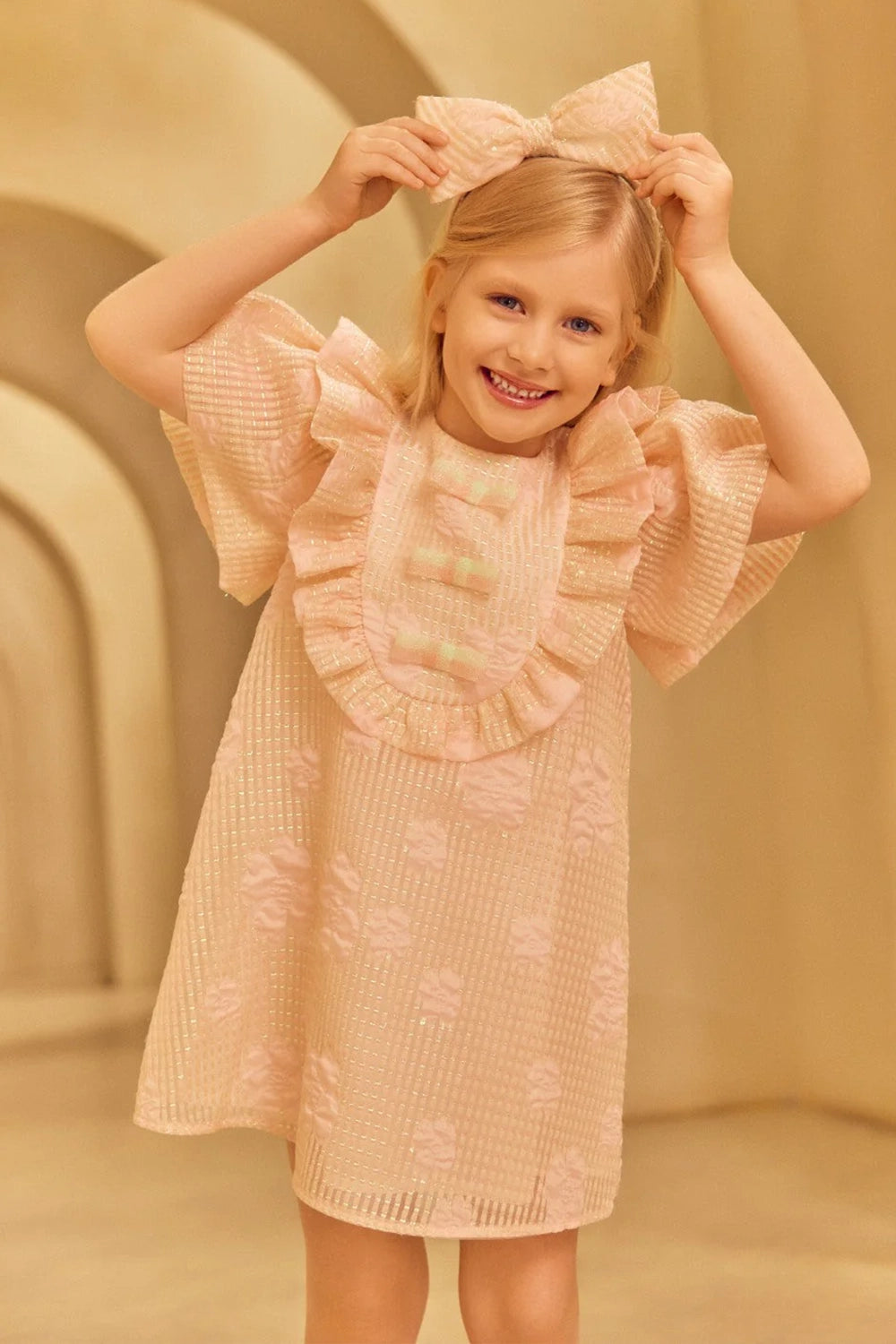 Charming A-line jacquard organza dress in light pink with voluminous ruffled shoulders and front shimmering bows in mint and pink