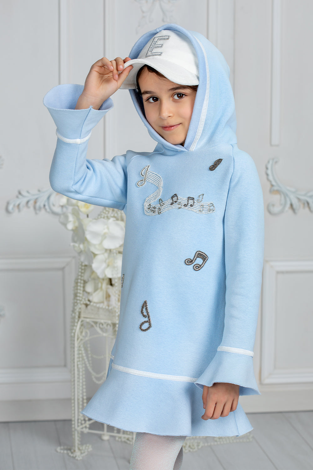 Sky blue tunic with a hood and musical embroidery