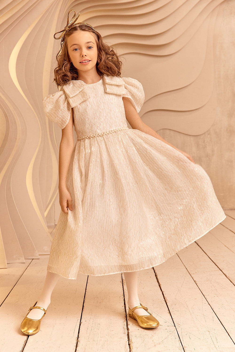 فستان من العاج وخيوط الذهب مع أقواس على الكتف