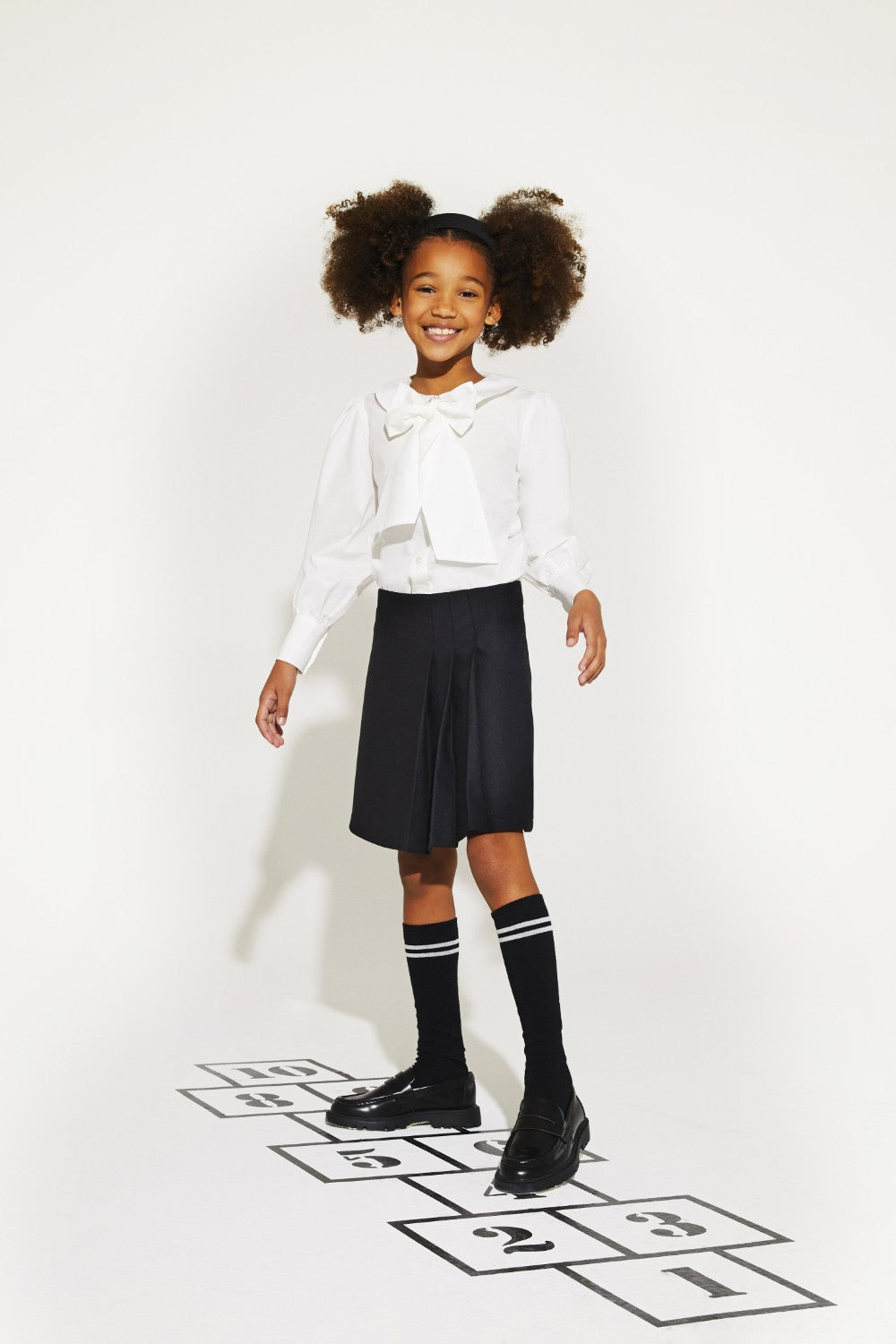 White woven cotton shirt with puffed sleeves and removable bow.