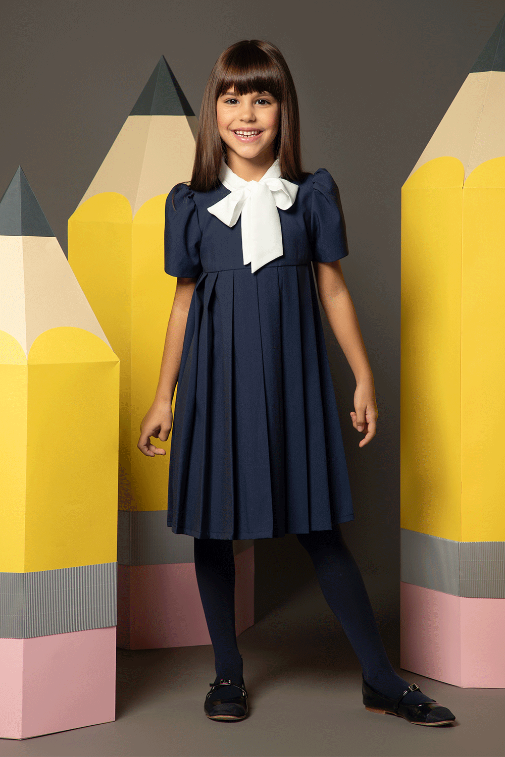 Navy pleated dress with contrasting white bow