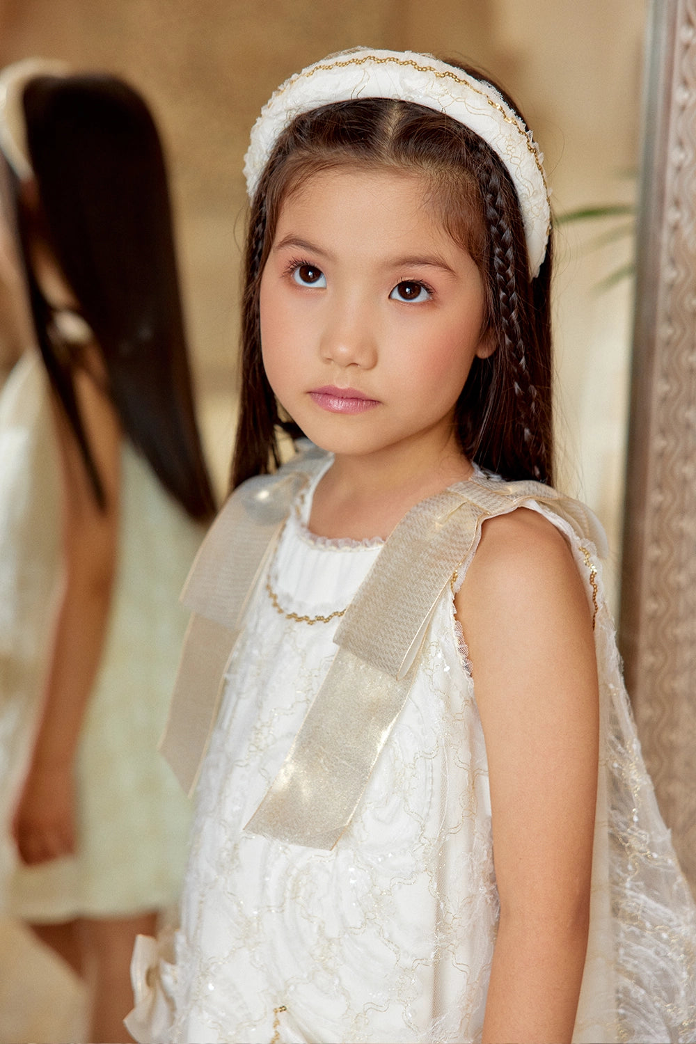 Ivory A-line lace dress with gold shoulder bows and pocket bow details
