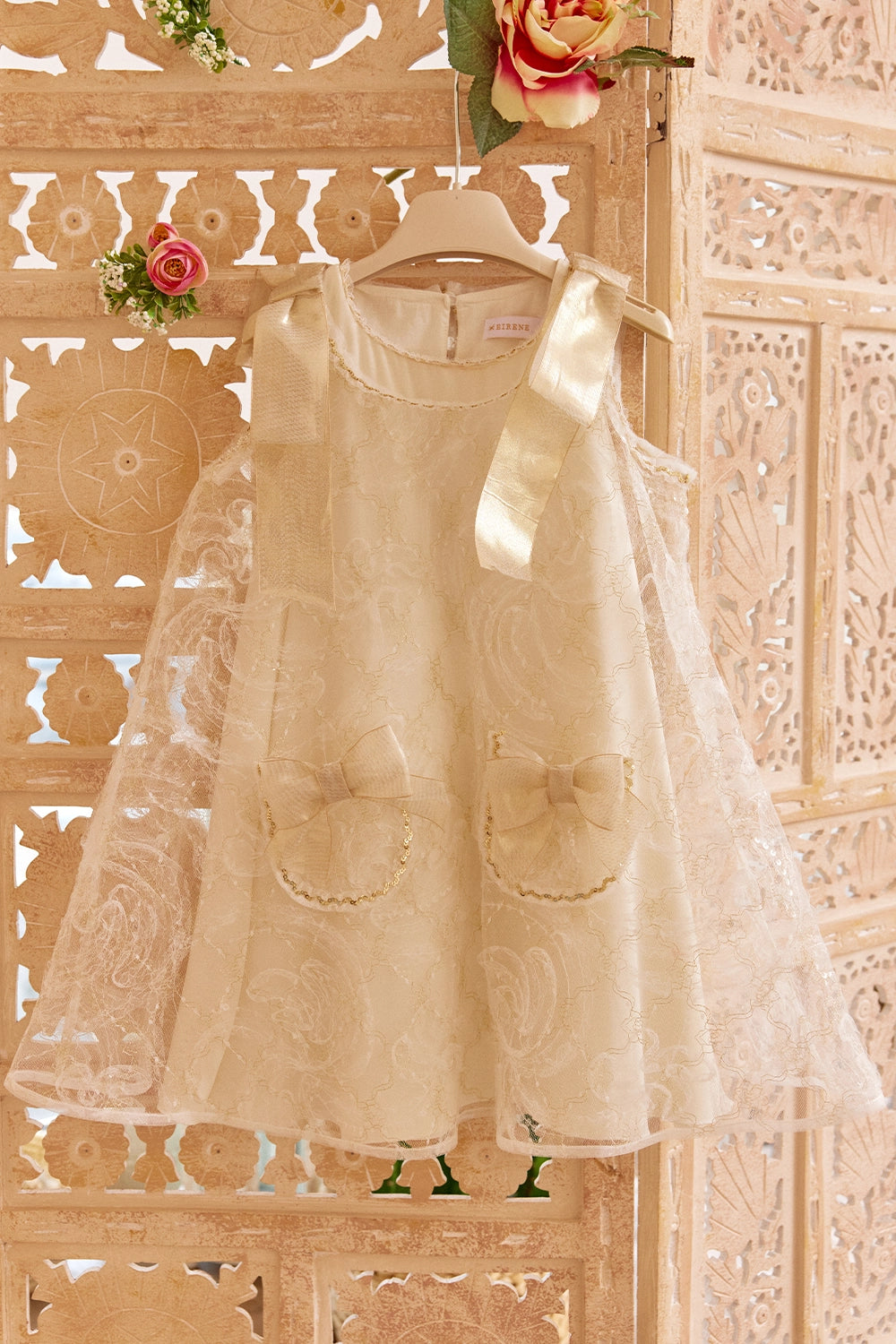 Ivory A-line lace dress with gold shoulder bows and pocket bow details