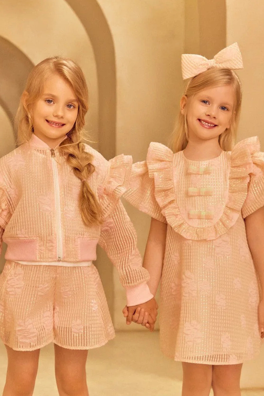 Charming A-line jacquard organza dress in light pink with voluminous ruffled shoulders and front shimmering bows in mint and pink