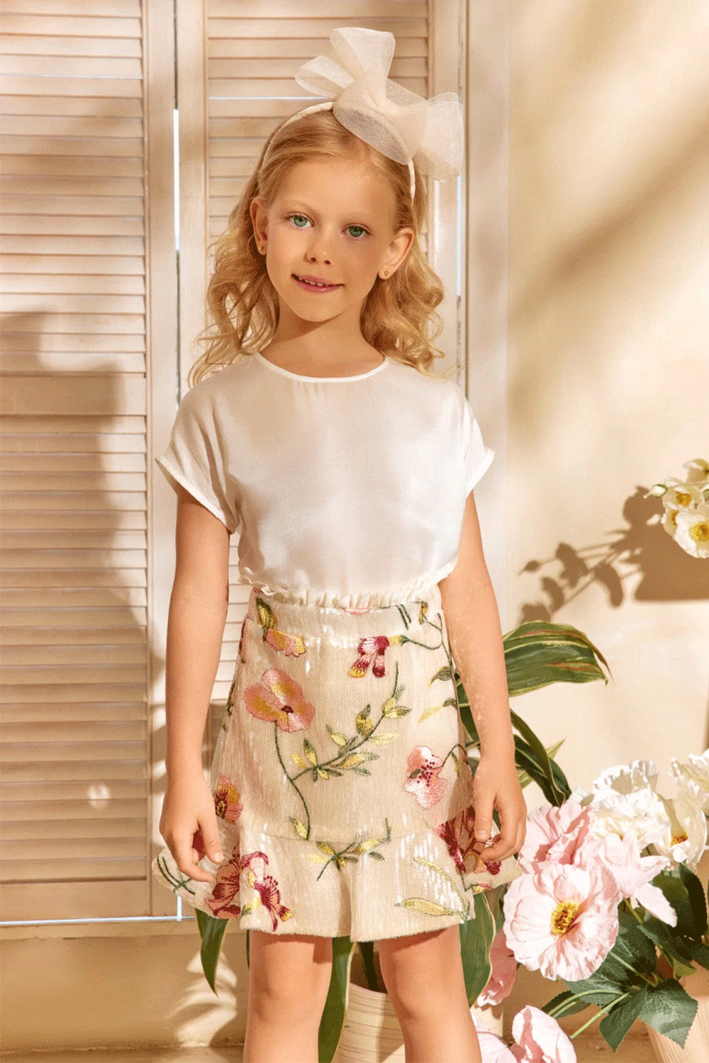 Ivory sequin set featurting a floral embroidered jacket with pleated trim and a matching mini skirt with frill