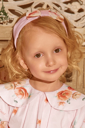 Soft pink headband with a charming bow, featuring delicate floral prints